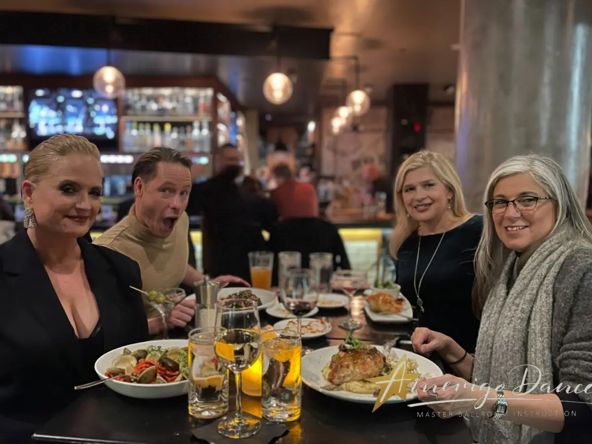 MI Fiesta Dance Studio team celebrating at a restaurant after a Pro-Am ballroom dance competition.