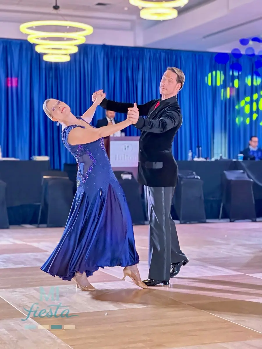 Elegant ballroom couple performing a smooth dance in flowing attire