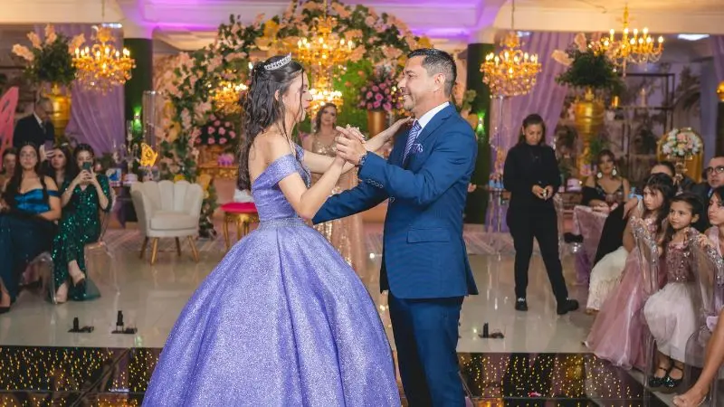 Young woman in a purple ball gown dancing with her father at a quinceañera celebration -  quinceañera dance lessons Waltham & Natick